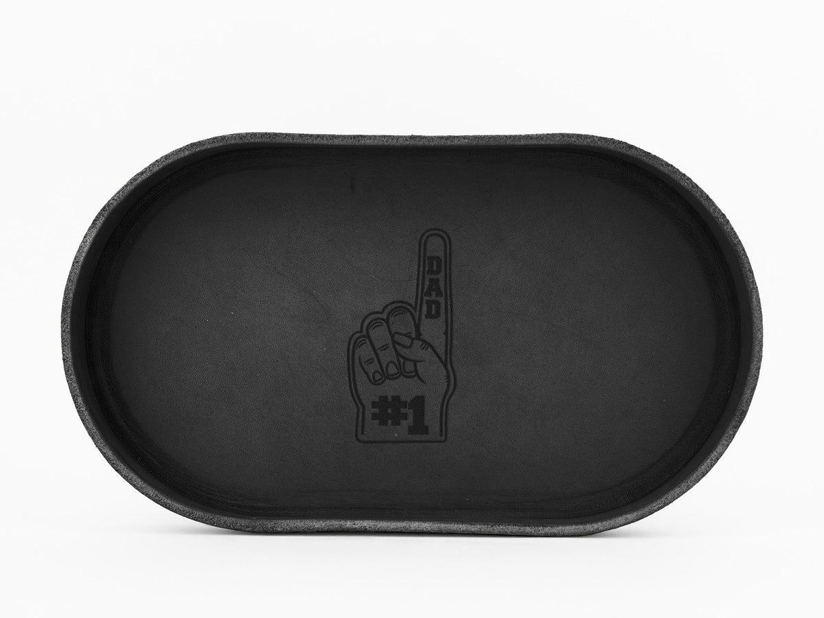 A black oval tray with an image of a foam finger showing DAD on the index finger and #1 on the palm, centered at the bottom of the tray.