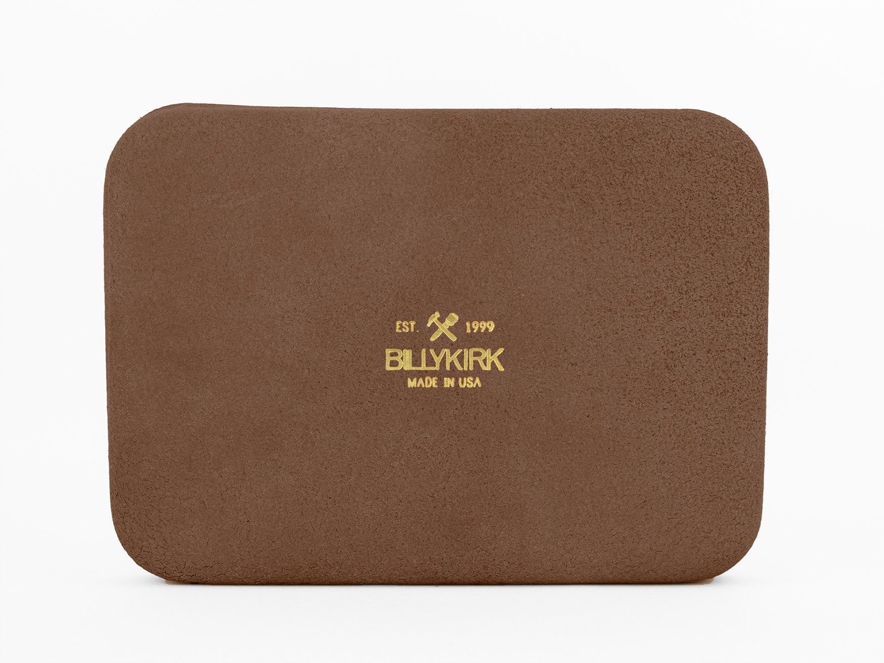 A rectangular brown leather item with rounded corners. Stamped in gold text at the center: EST 1999 BILLYKIRK MADE IN USA with two crossed tools above the brand name. The background is white.