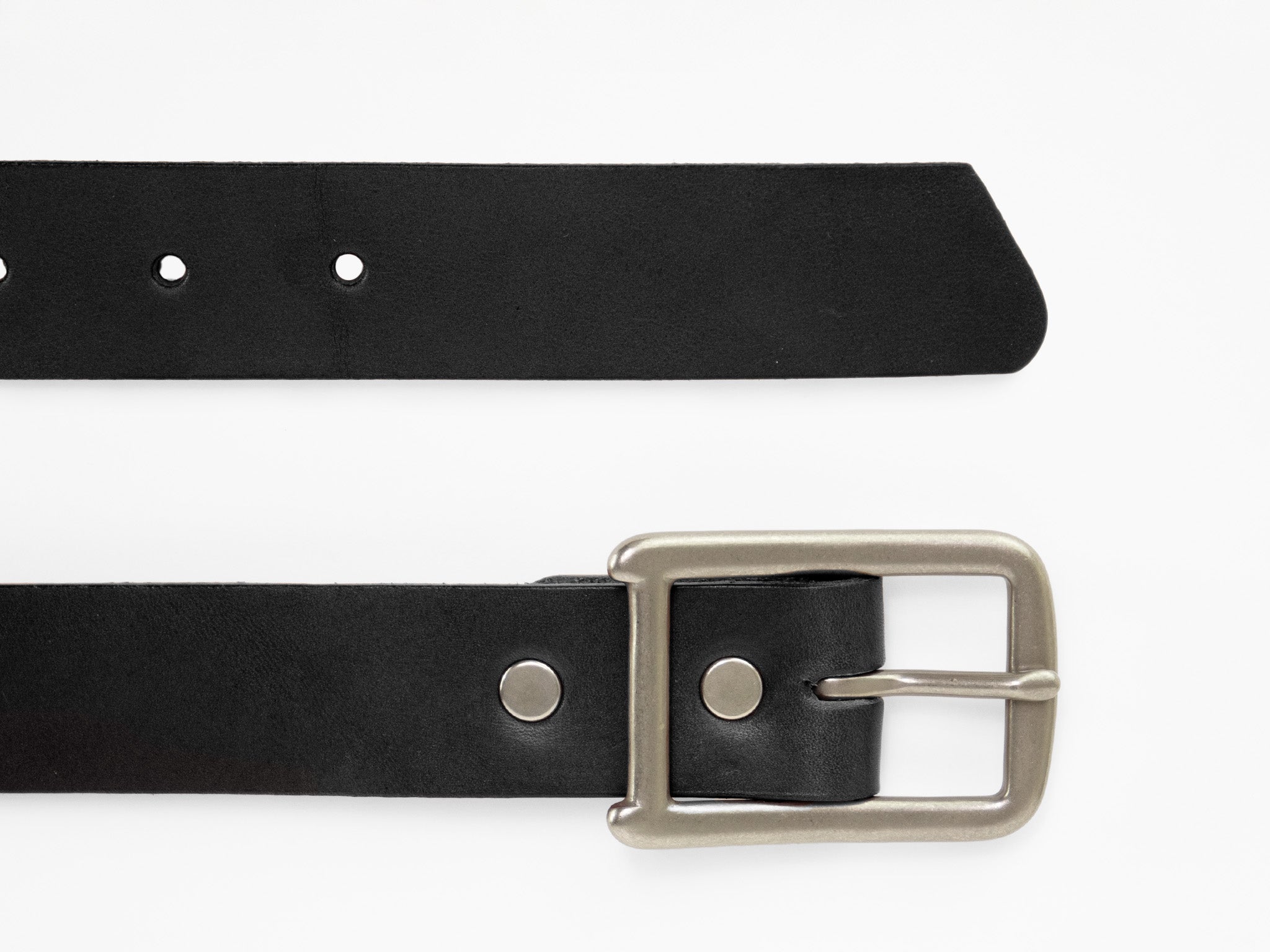A black leather belt with a silver metal buckle, shown horizontally on a white background. The belt tip is pointed with several adjustment holes visible.