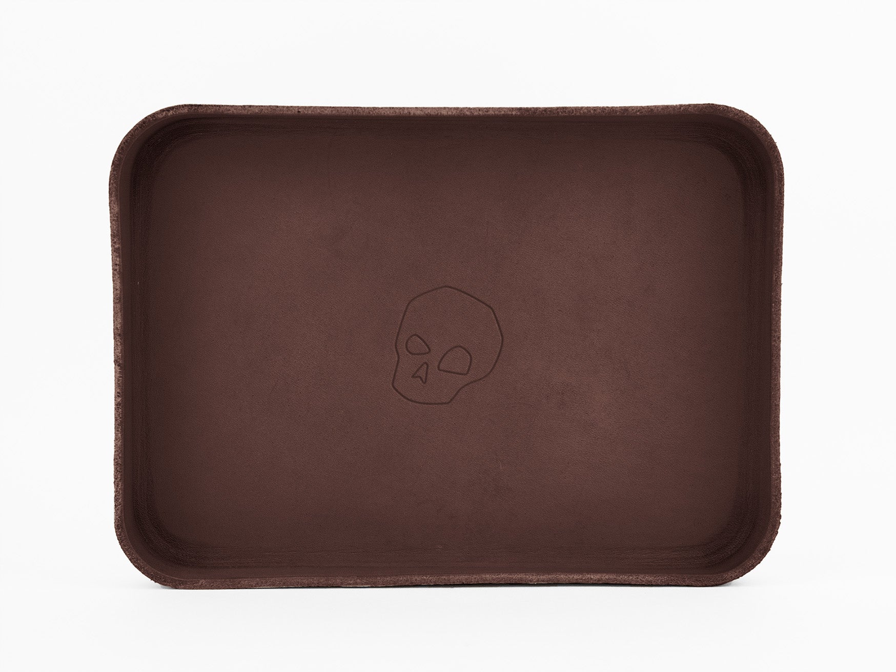 A rectangular brown tray with rounded edges, featuring a simple outline of a skull in the center. The background is plain white.