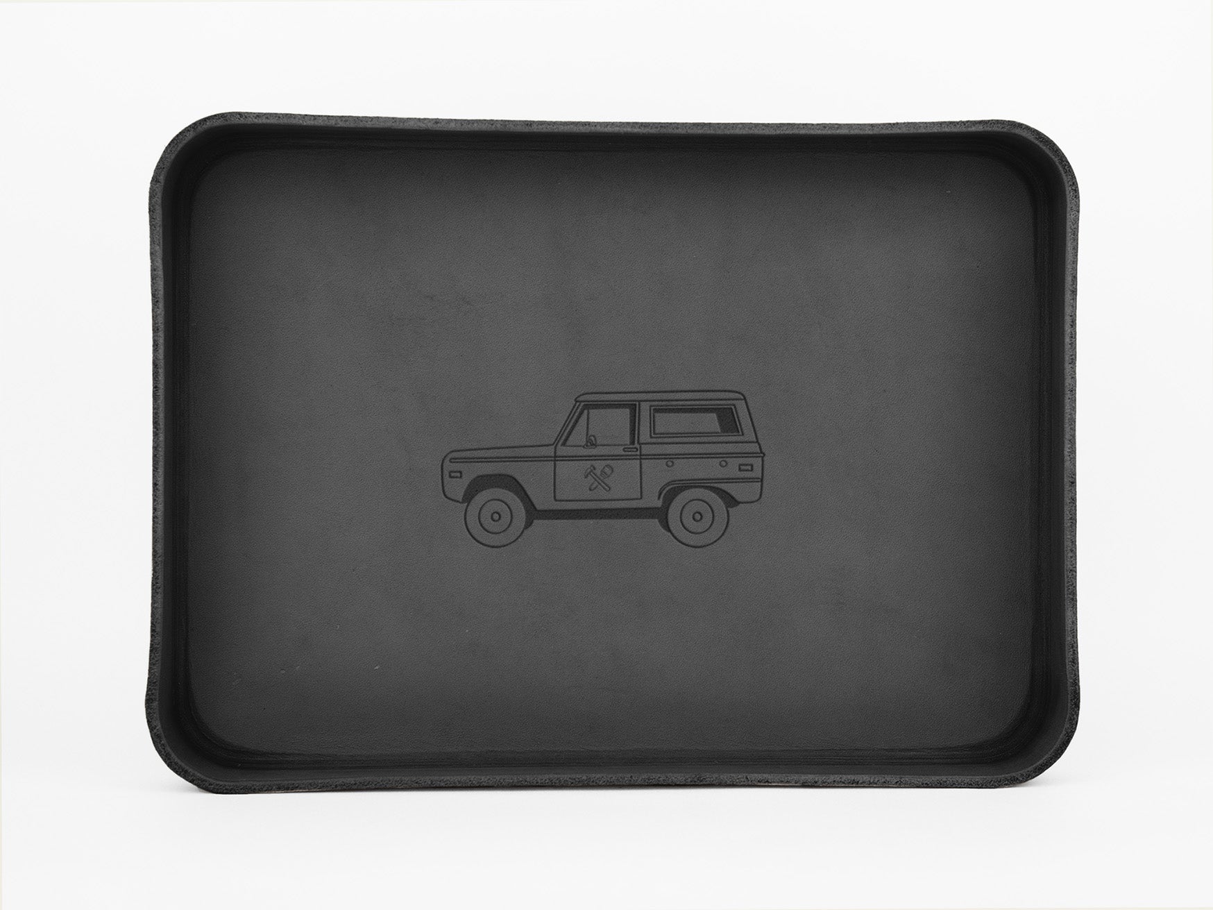 A black rectangular tray with raised edges featuring a simple outline drawing of an SUV-style vehicle in the center. The background is plain white.