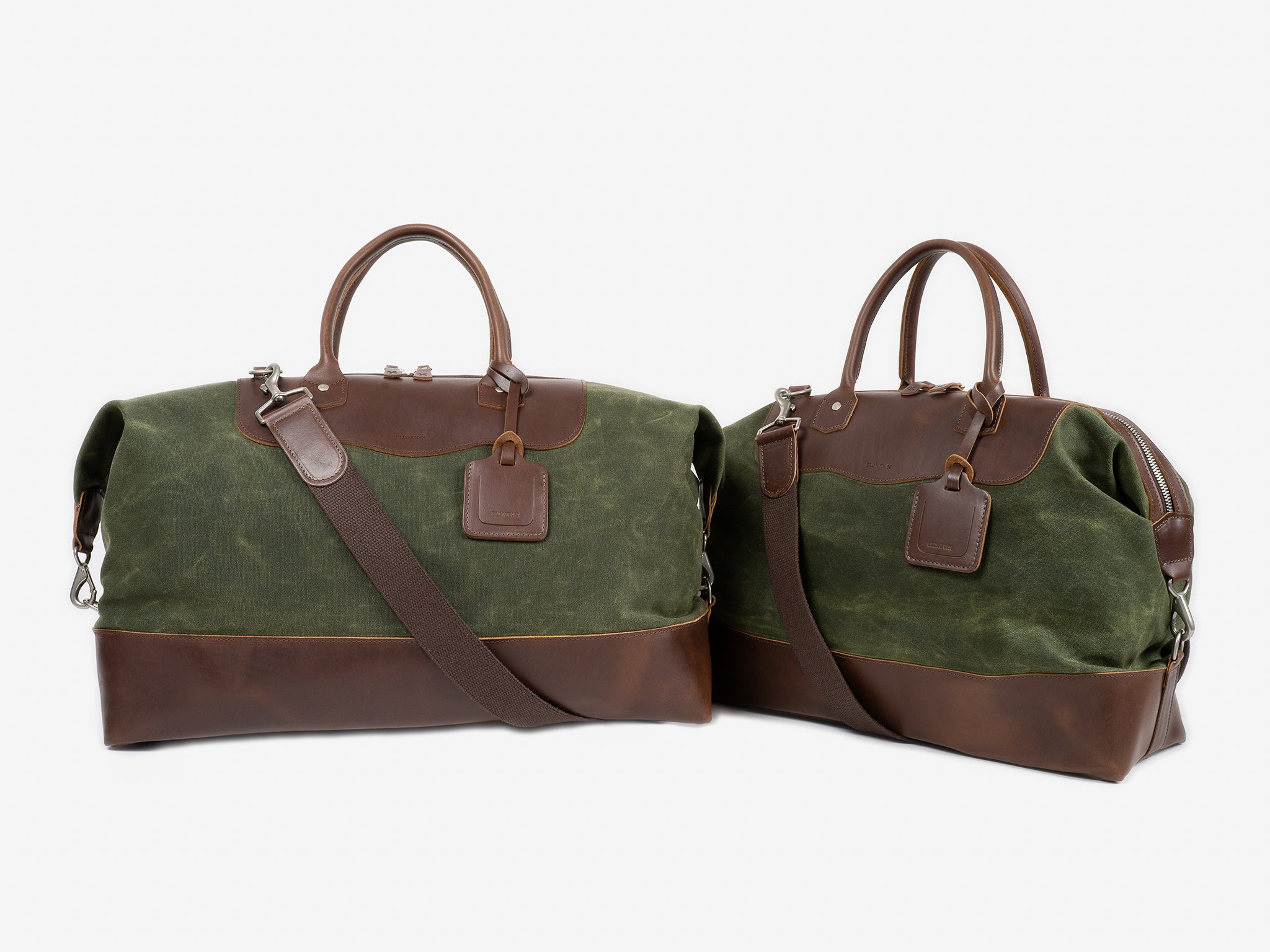 Two green and brown duffel bags with leather accents, handles, shoulder straps, and attached luggage tags, displayed on a white background.