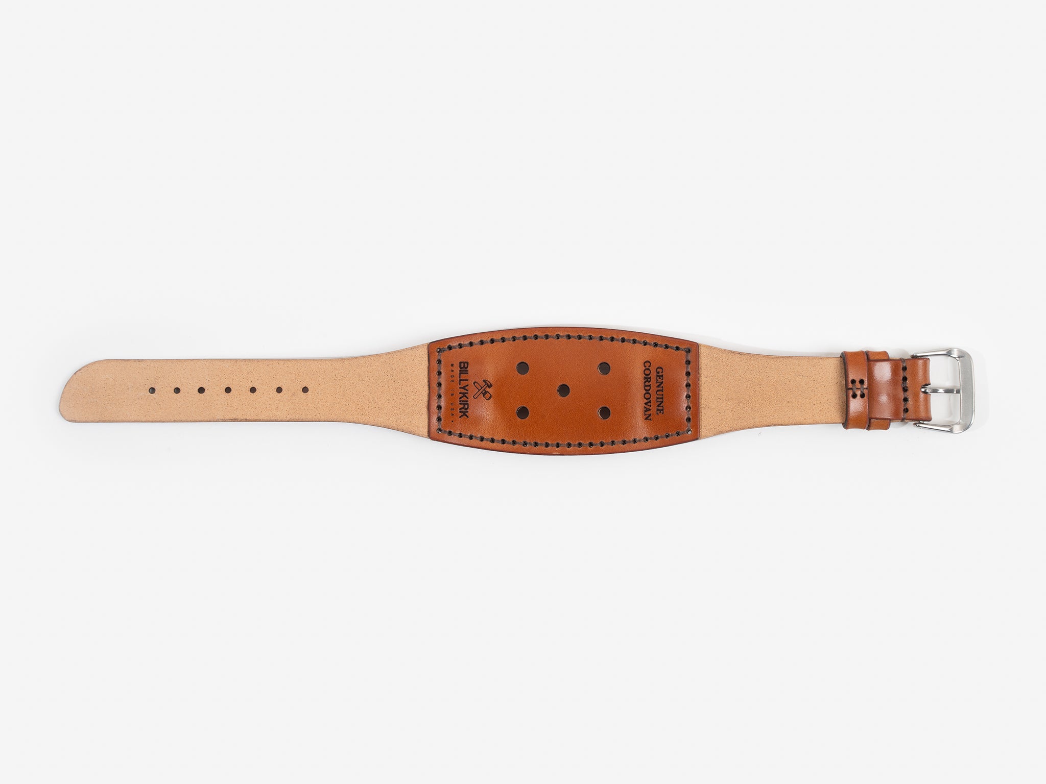 A wide, tan cordovan leather watch strap with black stitching, adjustment holes, a silver buckle, and the brand name BILLYKIRK embossed on it.