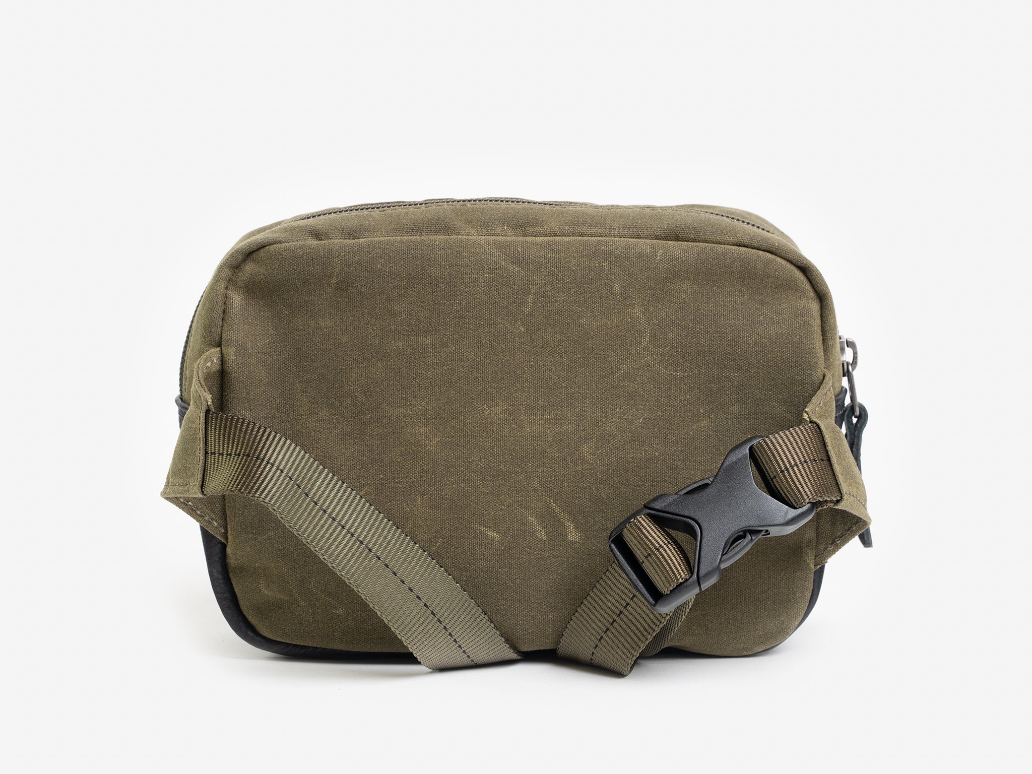 Back view of a small olive waxed canvas crossbody bag with adjustable strap.