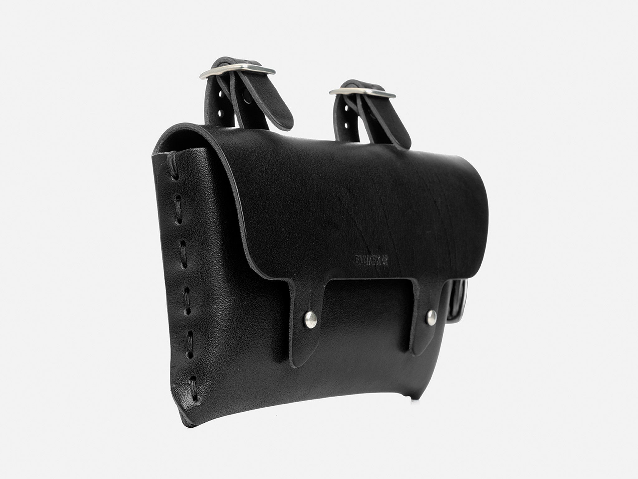 A black leather bicycle saddle bag with two buckle straps on top for mounting and metal rivets securing the sides, shown against a plain white background.
